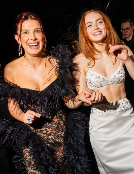 Millie Bobby Brown and Sadie Sink holding hands and smiling